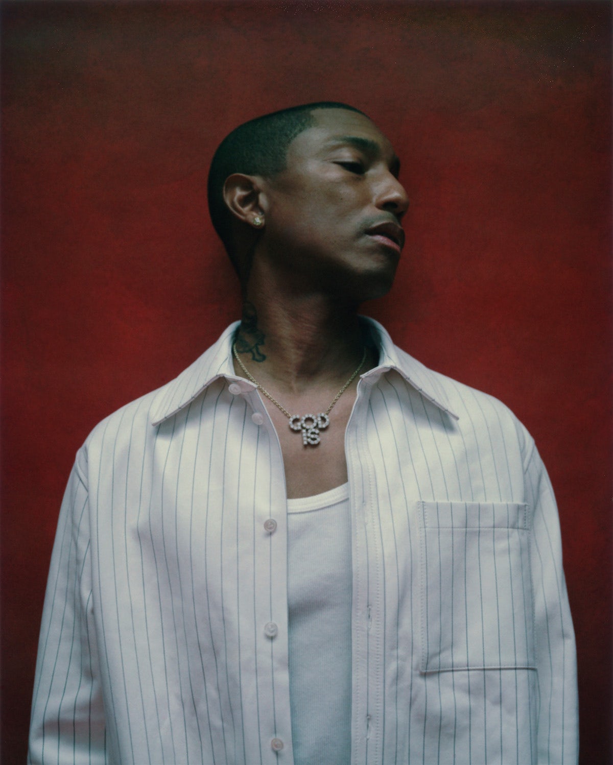 Portrait of Pharrell by Gabriel Moses against a red backdrop